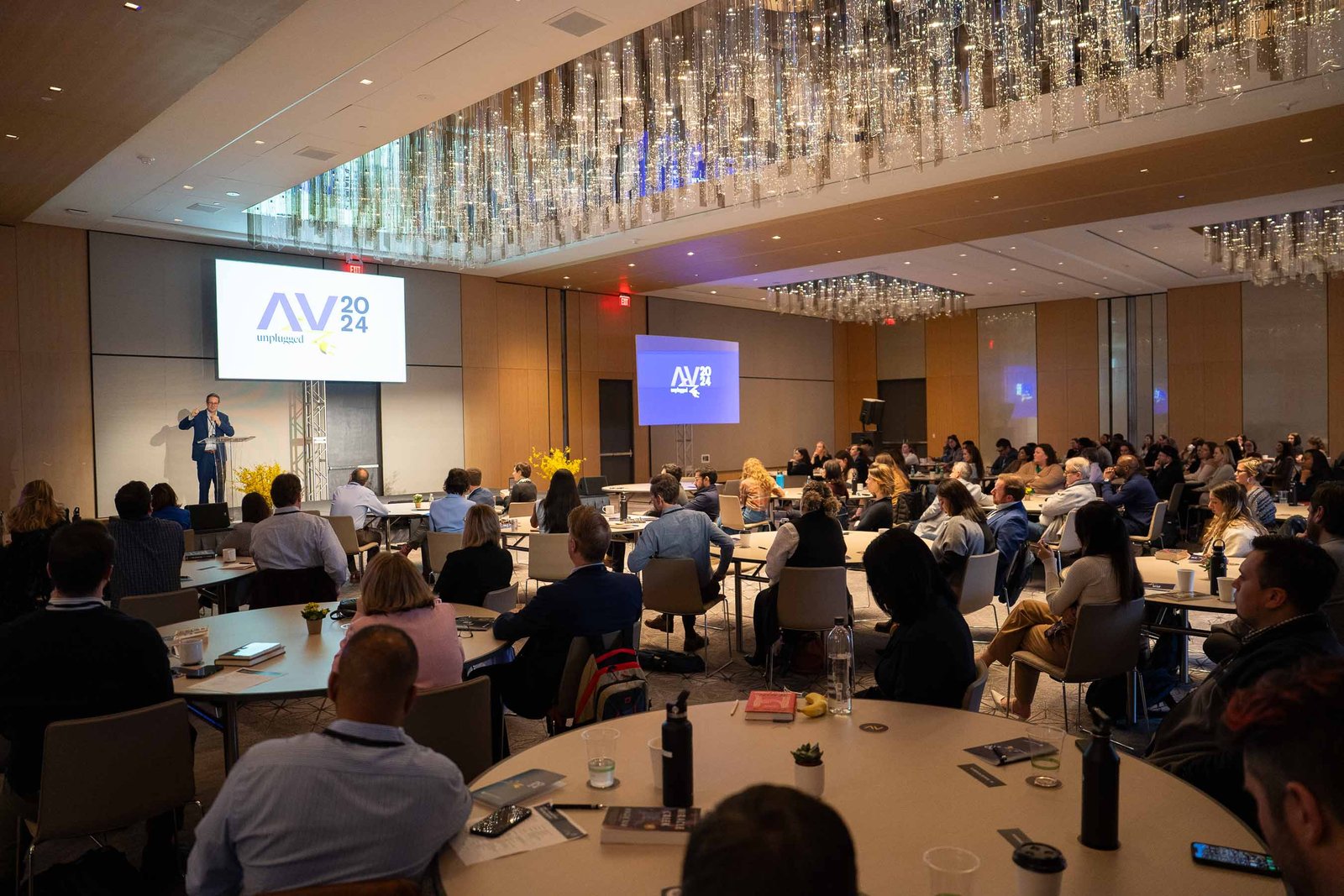 large hall arnold ventures conference full of people looking at presenter