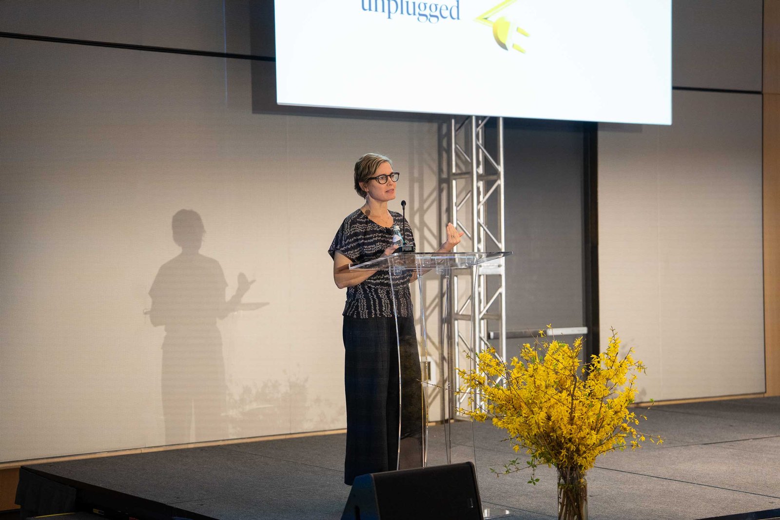 presenter on stage with screen