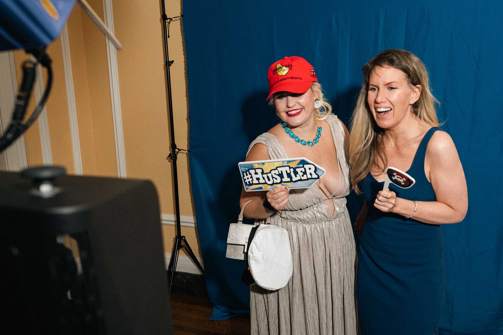 Woman in blue dress with man in red cap at Sailor's Ball 2024 NYC event