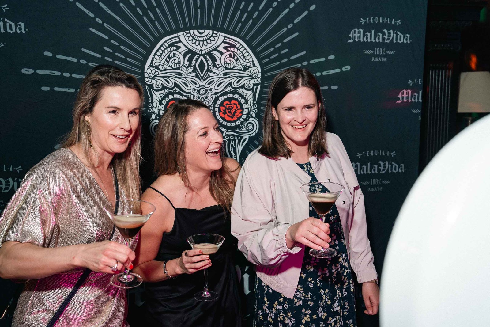 Women laughing with cocktails at Sailor's Ball 2024 NYC gala event