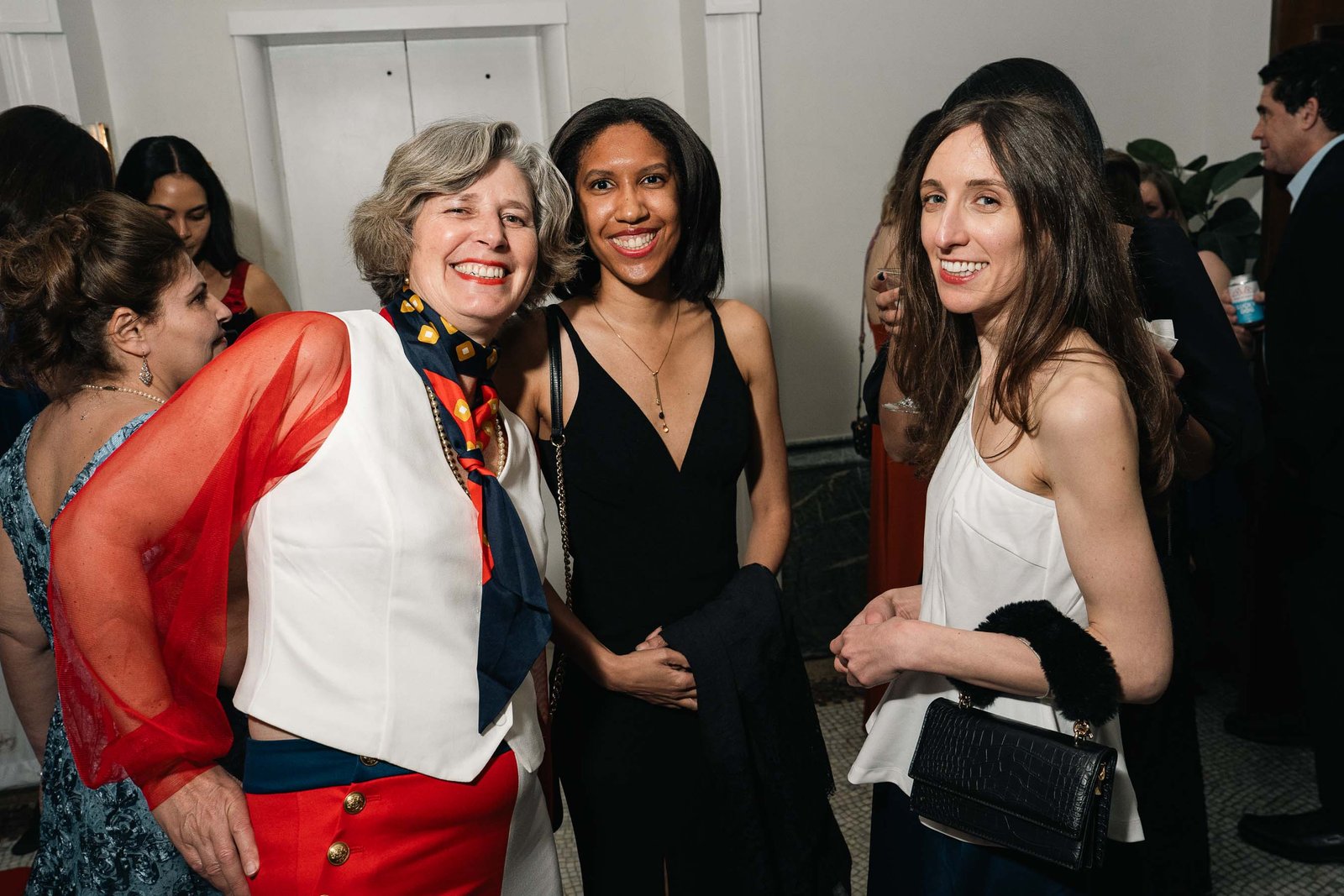 Three women in formal gowns at Sailor's Ball 2024 New York City event