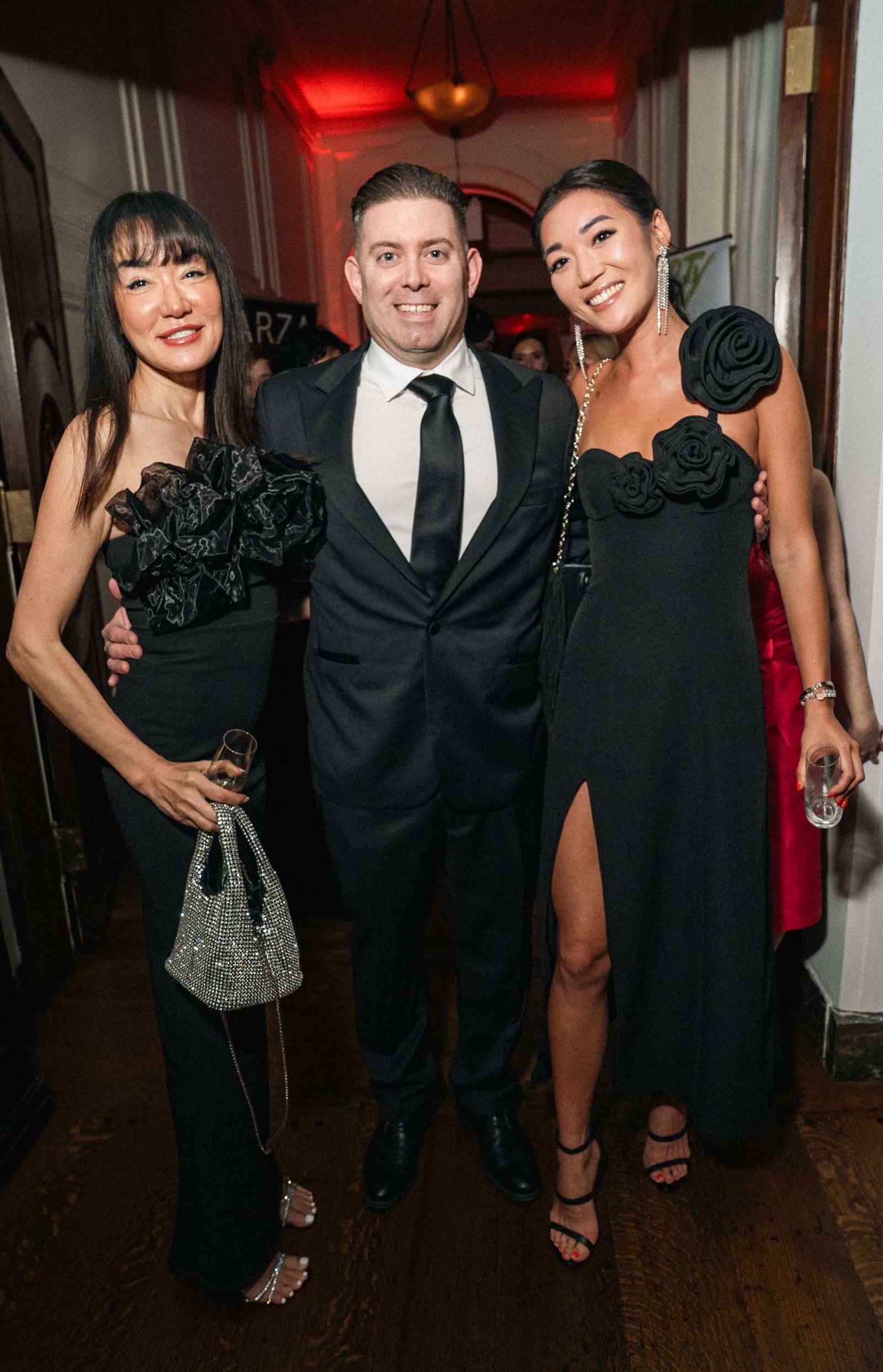 Three women in elegant gowns at Sailor's Ball 2024 New York City