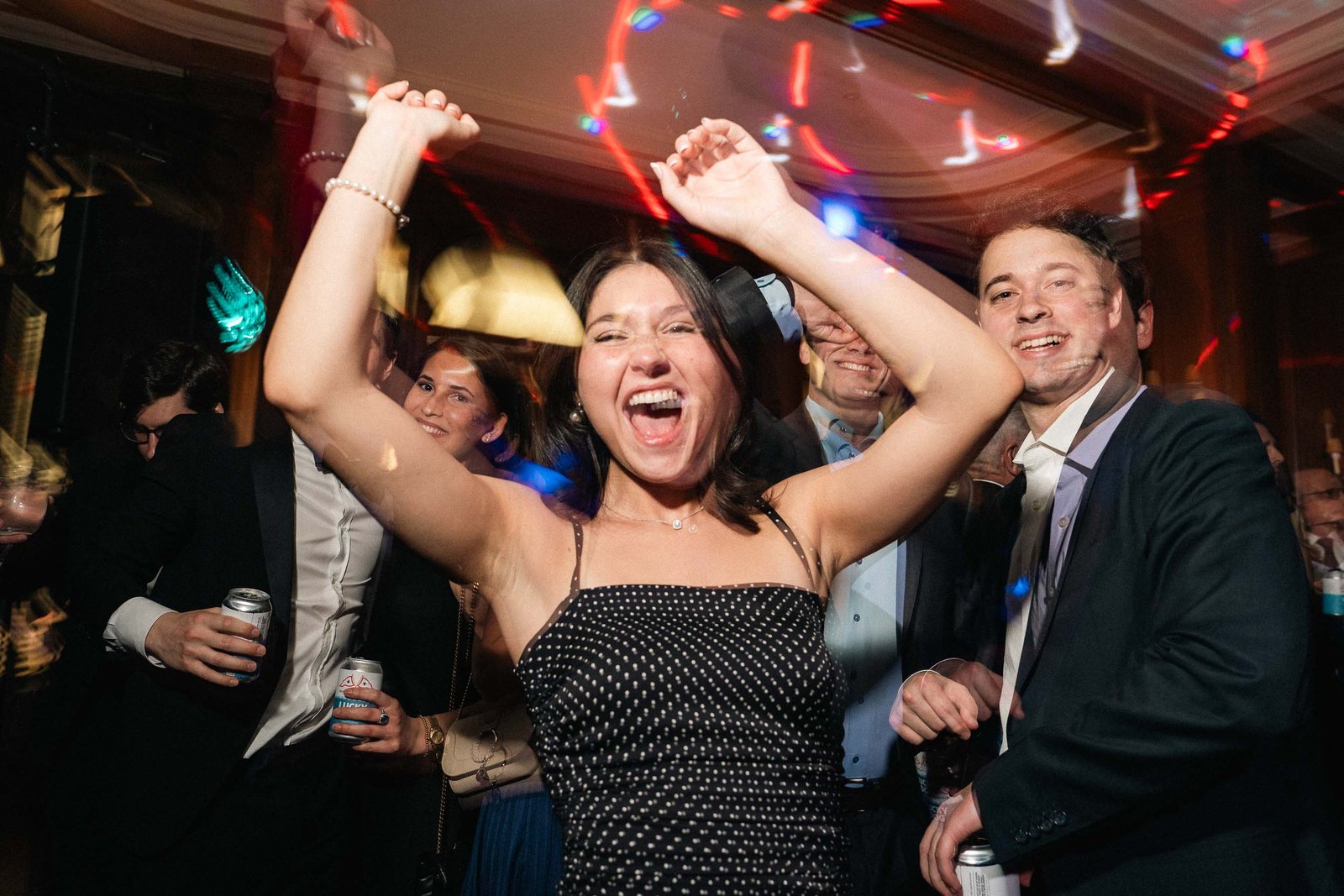 Woman celebrating with hands raised on dance floor Sailor's Ball 2024 NYC