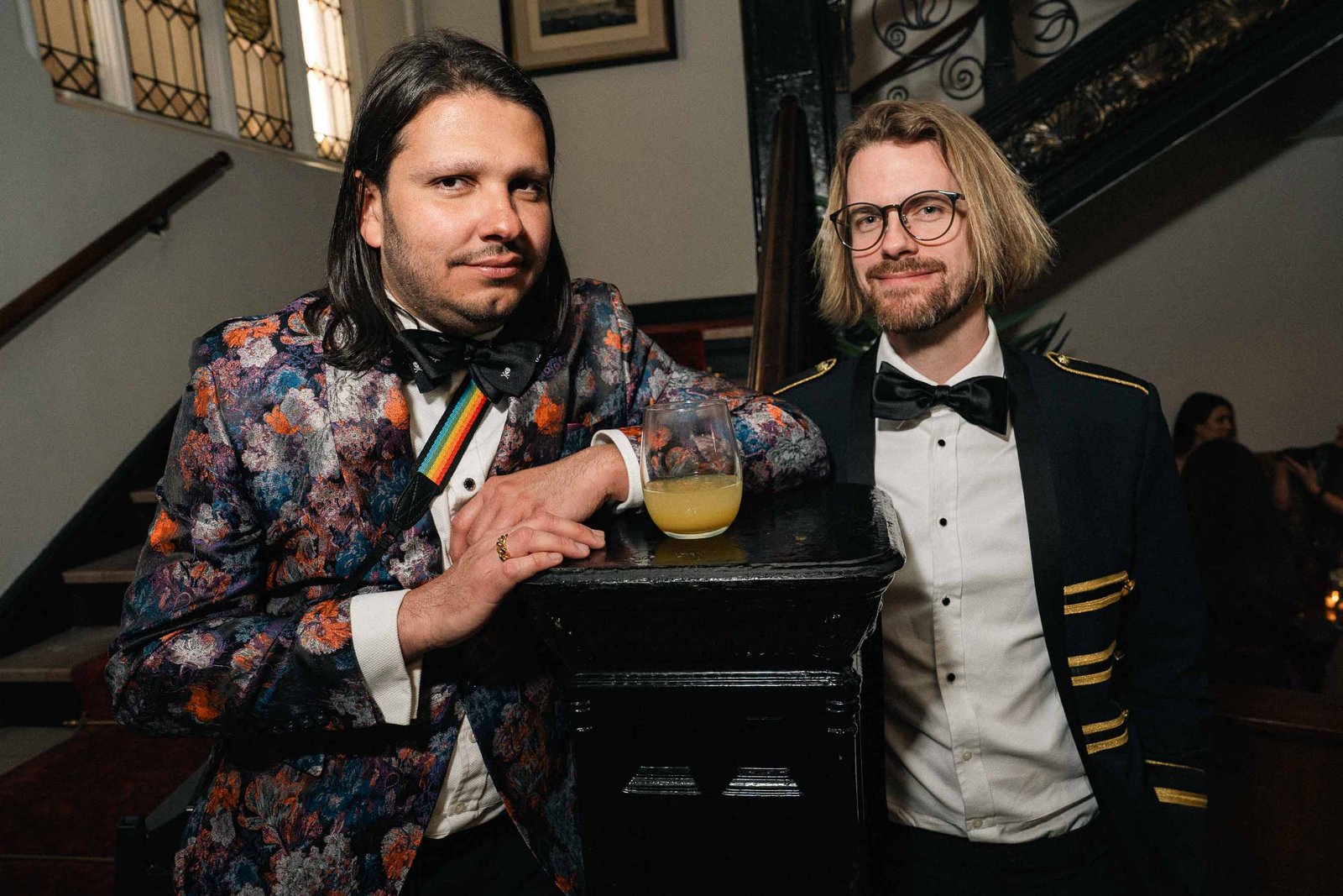 Two men in tuxedos with drinks at Sailor's Ball 2024 New York City event